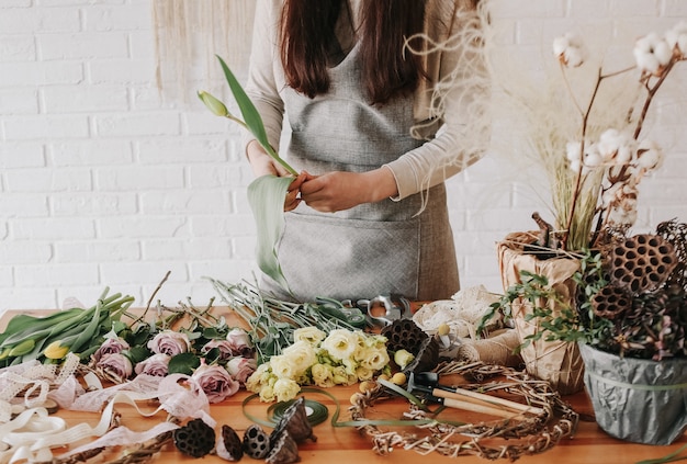 Femme fleuriste recueille bouquet décore différentes fleurs