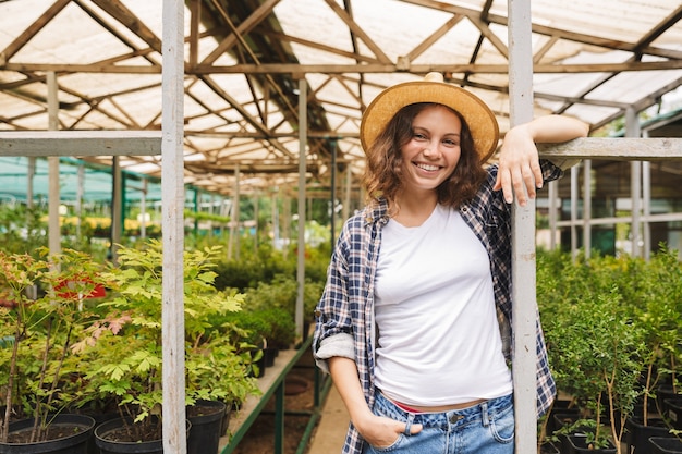 Femme fleuriste travaillant en serre sur les plantes