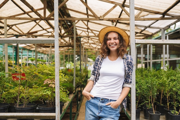 Femme fleuriste travaillant en serre sur les plantes