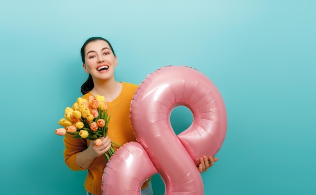 Photo femme avec des fleurs et un ballon en forme de huit