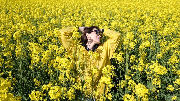 Femme et fleurs jaunes de colza