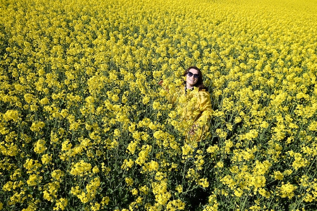 Femme et fleurs jaunes de colza