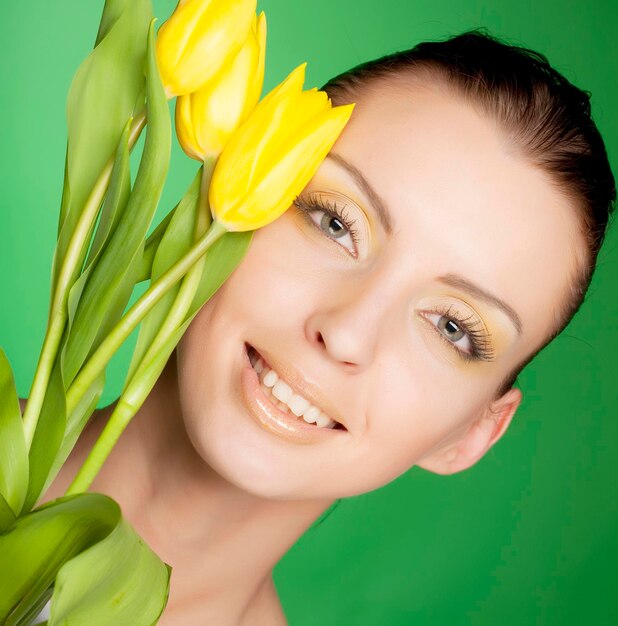 Femme avec des fleurs jaunes sur fond vert