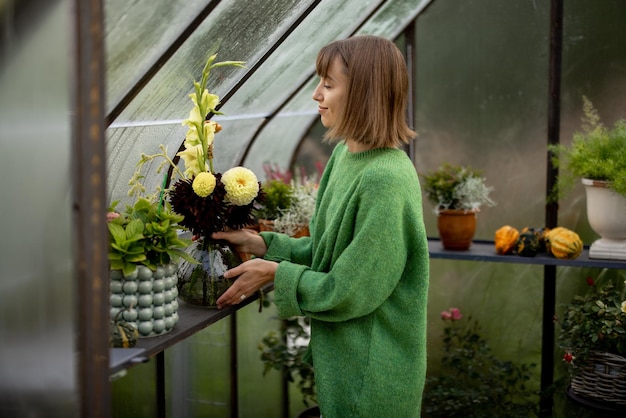 Femme avec des fleurs en serre