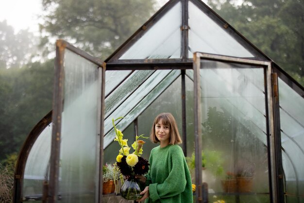 Femme avec des fleurs en serre