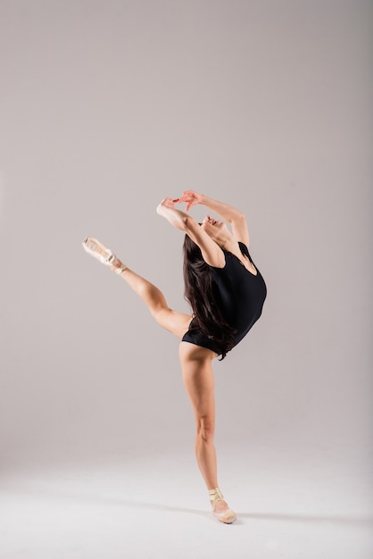 Femme flexible, danseuse de ballet en body noir, ballerine