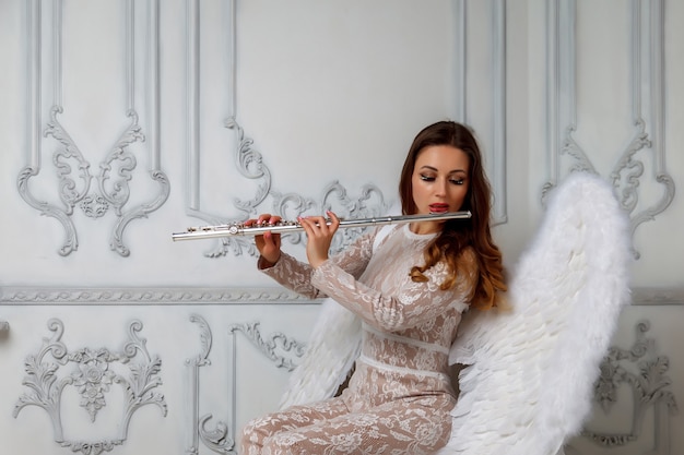 Femme à la flûte. Fille actrice en costume avec flûte sur fond clair