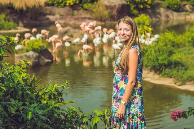 Femme sur fond de flamants roses sur un étang