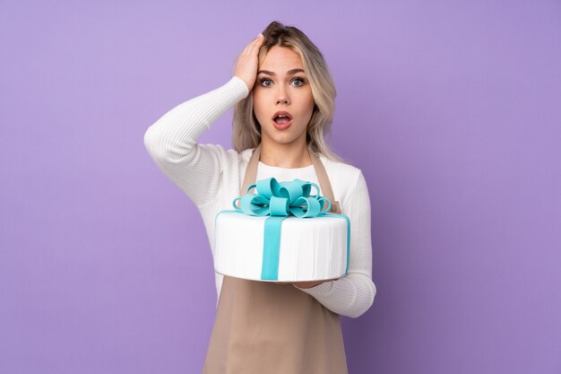 Femme sur fond isolé tenant un gros gâteau