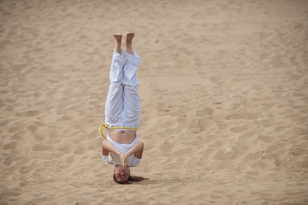 Femme forme la capoeira en plein air. Fille effectue un coup de pied