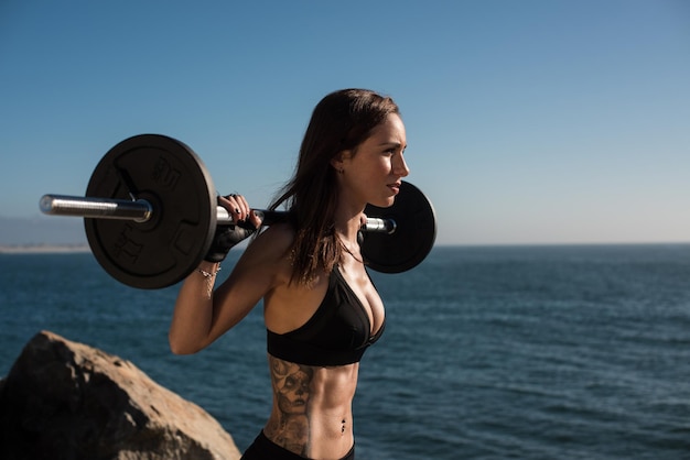 Femme de forme physique pompant des muscles soulevant le poids