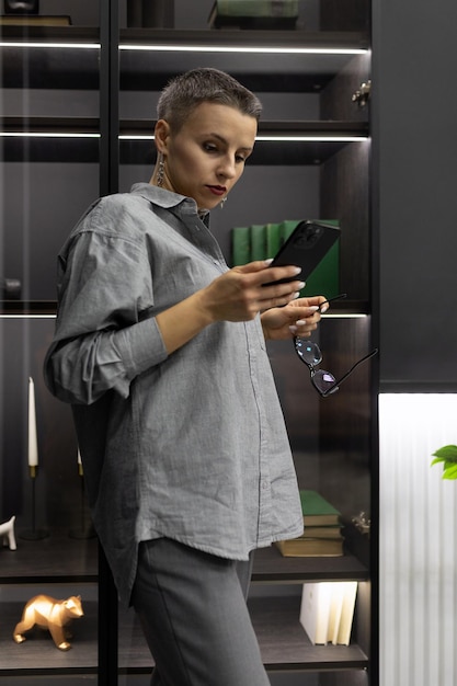 Femme forte dans un intérieur gris avec un téléphone dans les mains