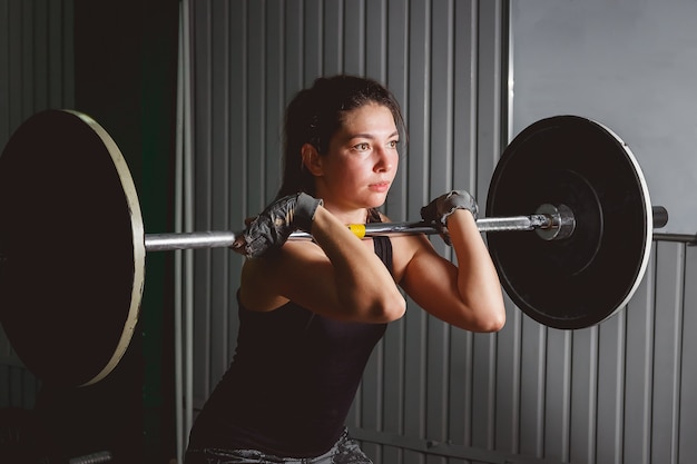 Femme forte, soulevant des haltères dans le cadre de l&#39;exercice de crossfit