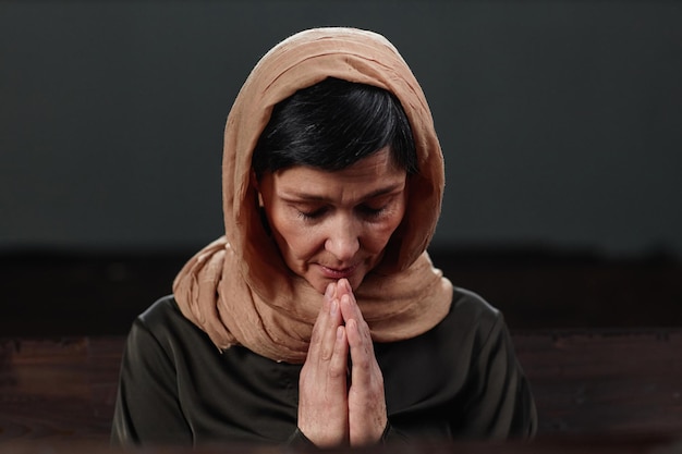 Femme en foulard priant à l'église