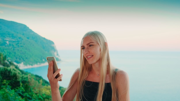 Femme fournissant un appel vidéo avec vue sur les vacances sur l'océan dans les pays chauds