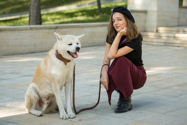 Femme française à la mode avec un gros chien blanc dans le parc