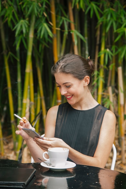 Femme française se connectant à Internet sur une terrasse de café