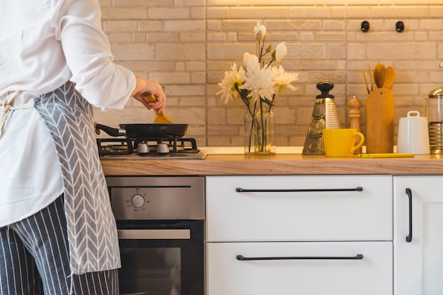 Femme frire sur pan cuisine vue