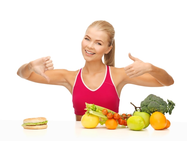 femme avec des fruits et un hamburger montrant de bons et de mauvais signes