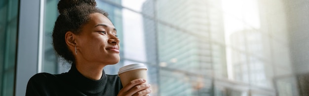 Femme gaie buvant du café pendant la pause travaillant dans le concept de travail à distance de café