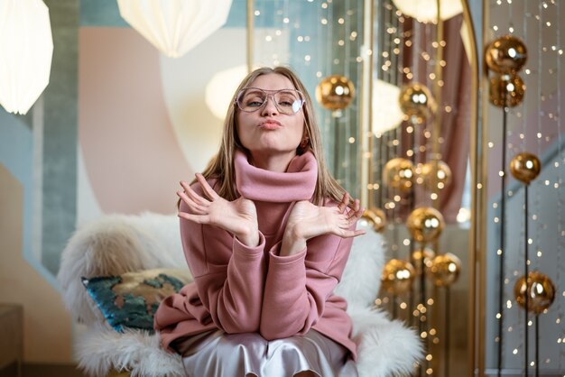 Femme gaie dans des verres qui pose en studio