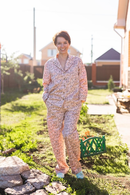 Femme gaie à la maison porter un pyjama d'été cour extérieure dans le concept de vêtements de nuit et de vêtements d'intérieur à la maison