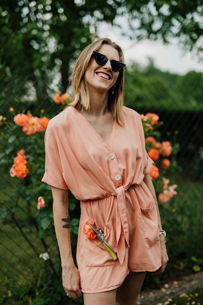 Femme gaie avec une rose orange