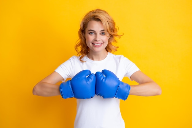 Femme en gants de boxe en fond isolé jaune Jeune femme réussie heureuse de son succès