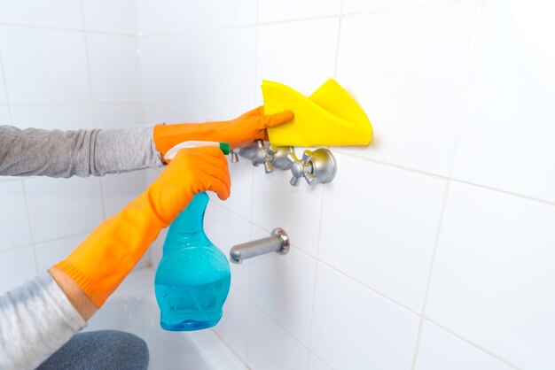 Femme avec des gants nettoyant la salle de bain