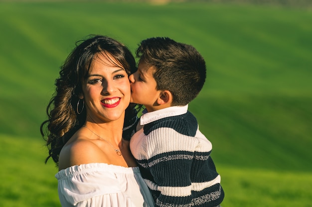 Femme et garçon sur la nature sur fond de champ de l'été. Poses sur la nature