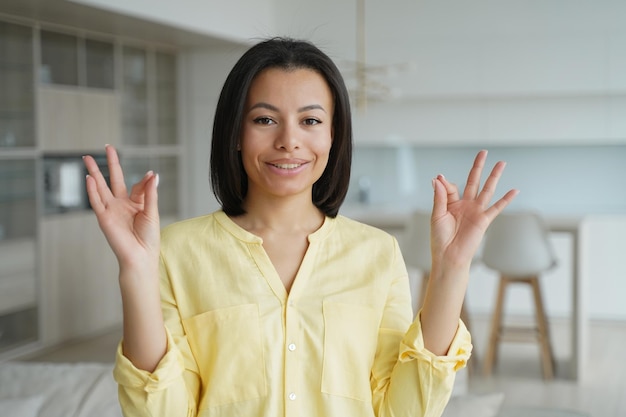 La femme garde le calme fait le geste de la main mudra pratique le yoga à la maison bien-être de soulagement du stress