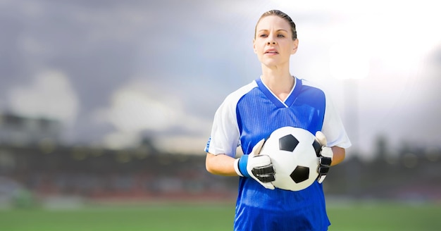 Femme de gardien de but de football tenant le ballon