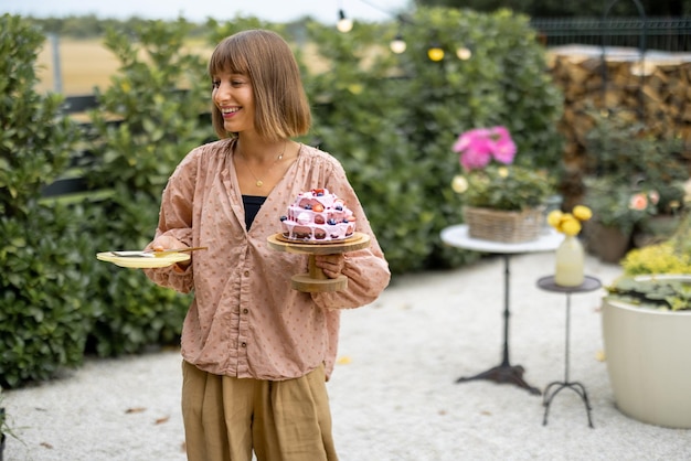 Femme avec gâteau de fête dans le jardin