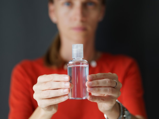 Femme avec un gel désinfectant pour la désinfection des mains et la prévention de la protection de la santé lors d'une épidémie de virus corona, d'épidémies et de maladies infectieuses.