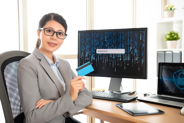 une femme gestionnaire confiante travaille dans une entreprise de sécurité des informations personnelles montrant son nouveau produit, une carte de crédit qui combine le concept de cybersécurité de compte en ligne.