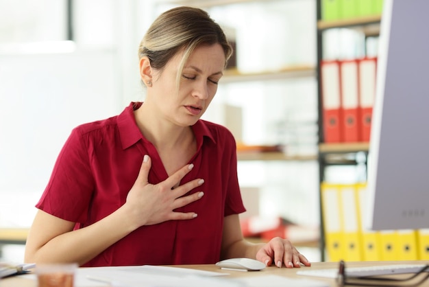 Une femme gestionnaire a du mal à respirer en mettant la main sur la poitrine une femme inquiète gère un problème de santé