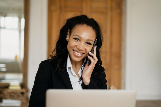 Une femme gestionnaire heureuse répond au téléphone à un client Travail préféré de l'administrateur de bonne humeur