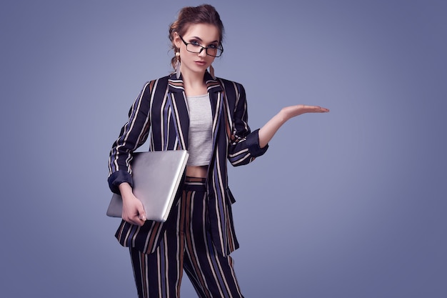 Femme glamour élégante en costume de mode et lunettes avec carnet