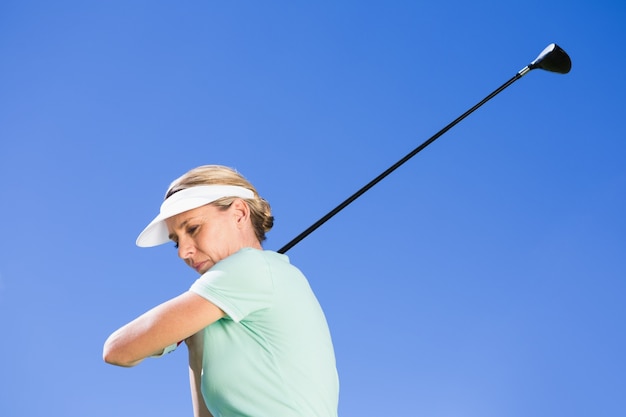 Femme golfeur de concentration prenant un tir