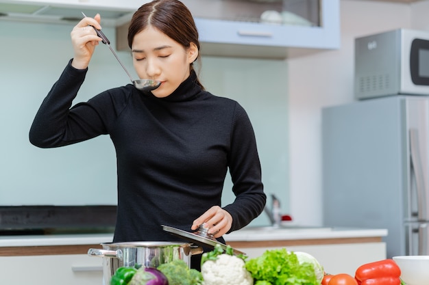 La femme goûte la soupe