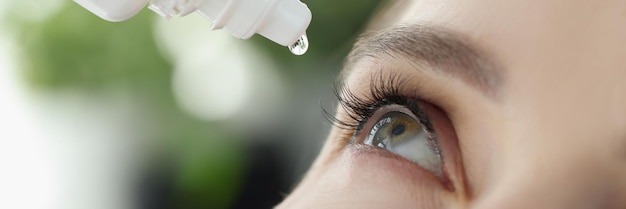 La femme goutte des gouttes oculaires dans les yeux pour les allergies. Sécheresse et irritation des muqueuses du concept oculaire