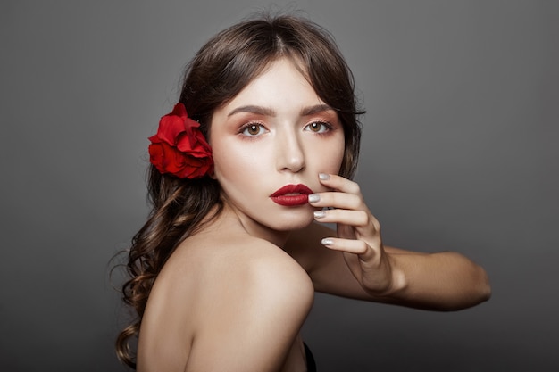 Femme avec une grande fleur rouge dans les cheveux