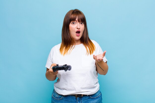 Femme grande taille bouche bée et étonnée, choquée et étonnée d'une incroyable surprise