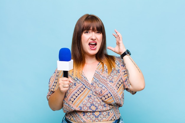 Femme grande taille hurlant les mains en l'air, se sentant furieuse, frustrée, stressée et bouleversée