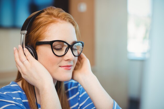 Femme graphiste écoute de la musique au casque