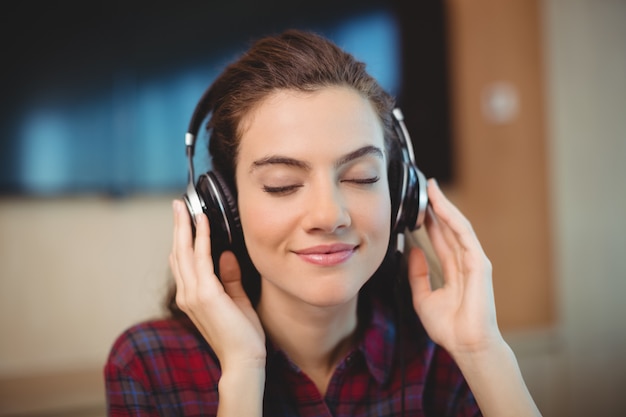 Femme graphiste écoute de la musique au casque