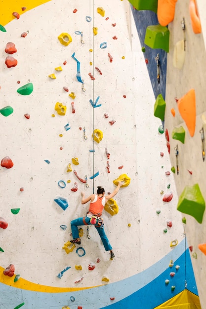 Une femme grimpant sur le mur.