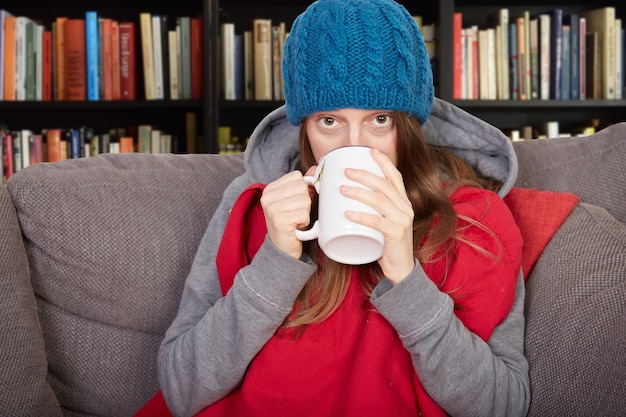 Femme avec la grippe assise sur le canapé