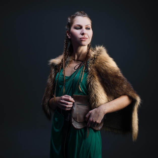 Une femme guerrière viking dans un portrait de cape de fourrure sur fond noir