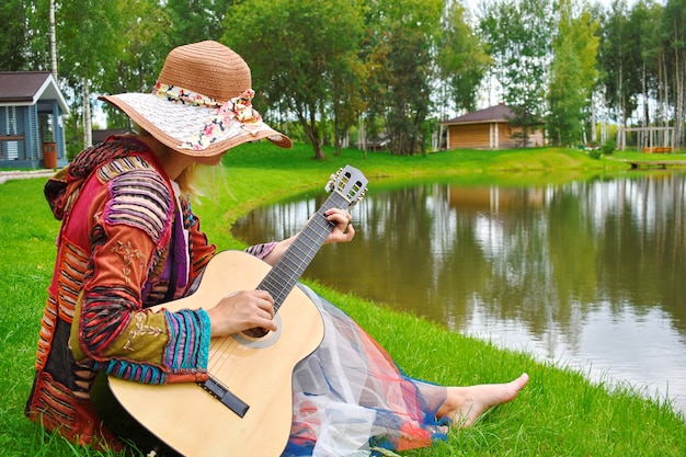 Femme avec une guitare sur le lac